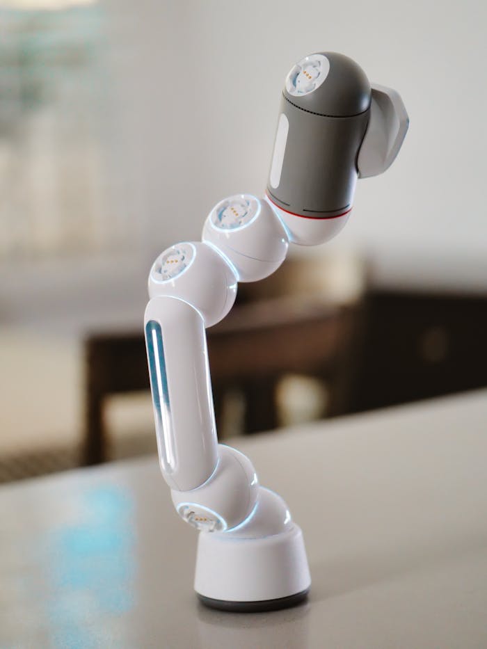 Close-up of a white robotic arm on a desk, showcasing advanced technology.